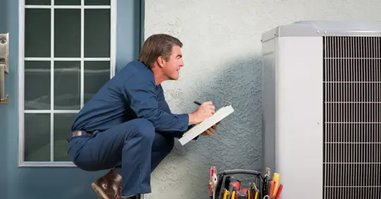 HVAC tech inspecting outdoor unit